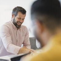 Candid portrait of confident man in his 40s at conference table, business meeting, professional occupation, relaxation, enjoyment